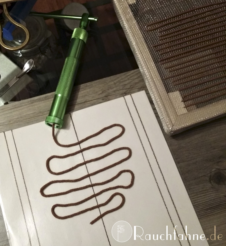 An extruded dough snake and finished sticks to be dried on the drying rack in the picture on the right.